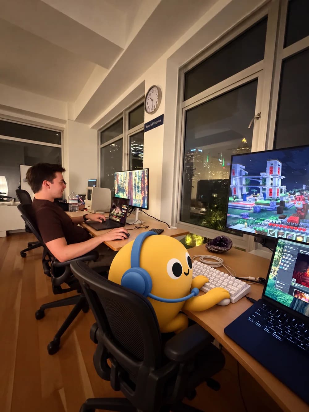 A yellow agent and a teammate playing Minecraft at their desks